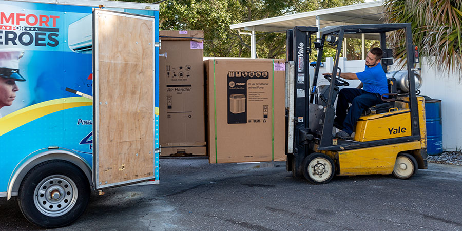 Campbell Comfort System's technician loading trailer with new hvac equipment